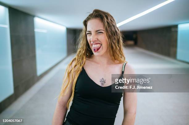 portrait of young woman sticking out her tongue - funny face woman stock pictures, royalty-free photos & images
