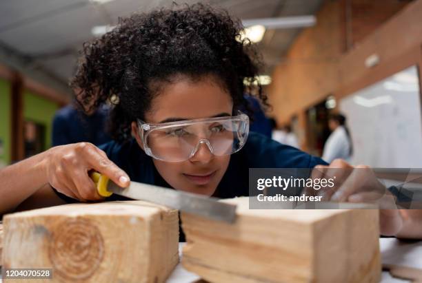 college-student in einer klasse schleifen ein stück holz - ausbildung und tischler stock-fotos und bilder