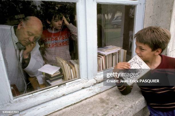 The Priest And The Mischievous In France In 1987 - A mischievous young boy eagerly awaits the start of the catechism class performed at the rectory-a...