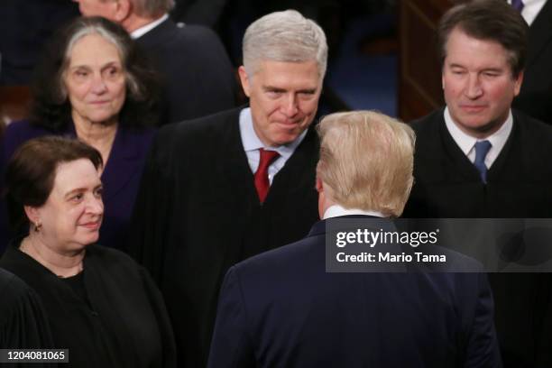 President Donald Trump greets Supreme Court Justice Neil Gorsuch ahead of the State of the Union address in the chamber of the U.S. House of...