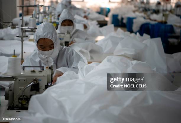 This photo taken on February 28 shows workers sewing hazardous material suits to be used in the COVID-19 coronavirus outbreak, at the Zhejiang Ugly...