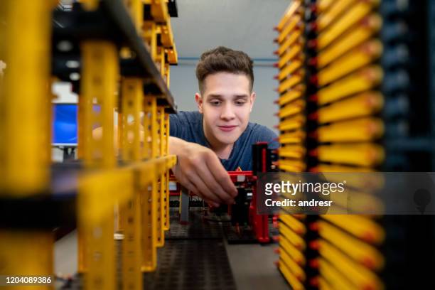 estudiante en una clase de ingeniería trabajando en un robot - mechatronics fotografías e imágenes de stock