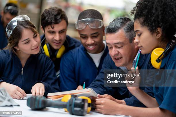 lehrer im gespräch mit einer gruppe von industriedesign-studenten - berufsausbildung stock-fotos und bilder