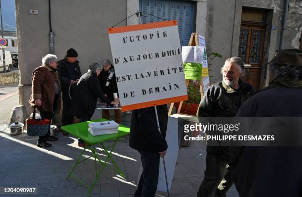 Member of the "S'engager ensemble pour Saillans" electoral list carries a placard reading "Todays utopia is tomorrows truth" while campaigning for...