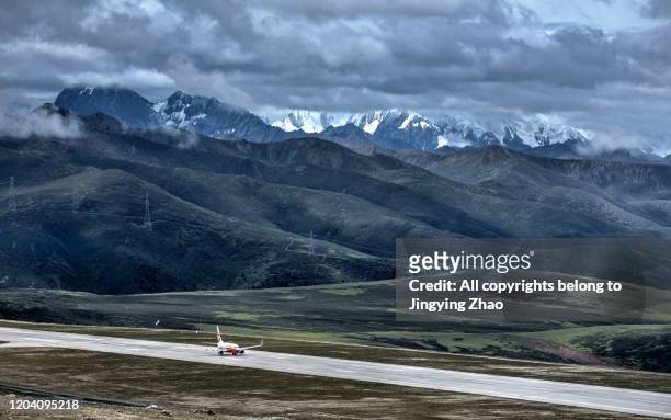 a plane take off from a high altitude airport in a cloudy day - new journey stock pictures, royalty-free photos & images
