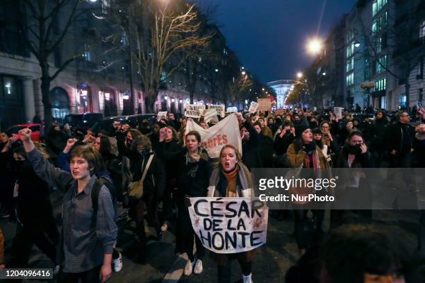 Feminist activists holding signs demonstrate outside the Salle Pleyel in Paris as guests arrive for the 45th edition of the Cesar Film Awards...