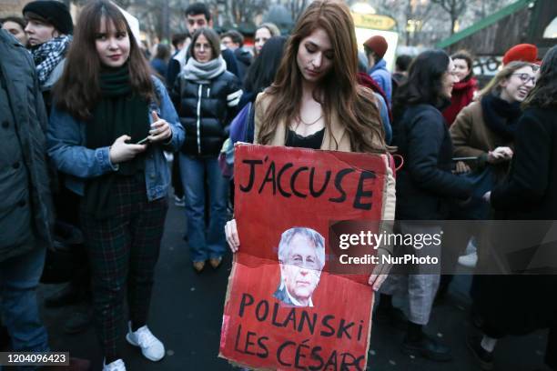 Feminist activists holding signs demonstrate outside the Salle Pleyel in Paris as guests arrive for the 45th edition of the Cesar Film Awards...