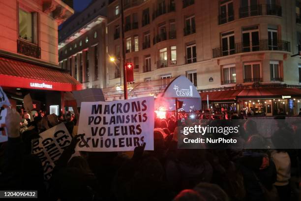 Feminist activists holding signs demonstrate outside the Salle Pleyel in Paris as guests arrive for the 45th edition of the Cesar Film Awards...