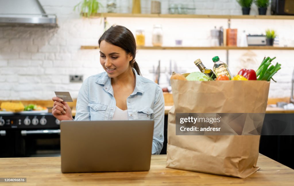 Woman at home buying groceries online