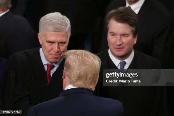 President Donald Trump greets Supreme Court Justice Neil Gorsuch as Supreme Justice Brett Kavanaugh looks on ahead of the State of the Union address...