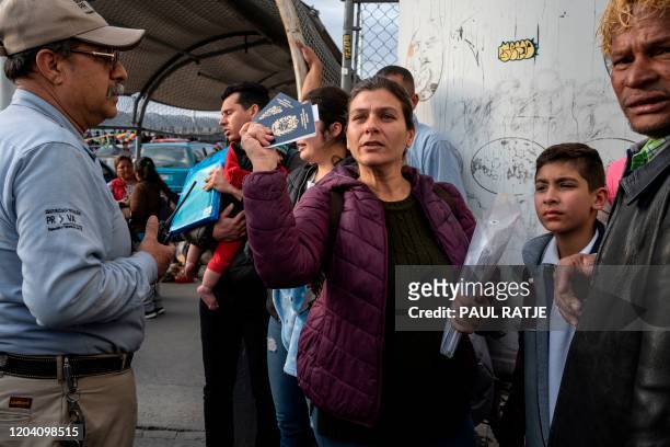 Venezuelan citizen Karilina Hernandez, aged 40, shows her and her 11 year-old son Joel Davids passports as Mexican immigration authorities try to...