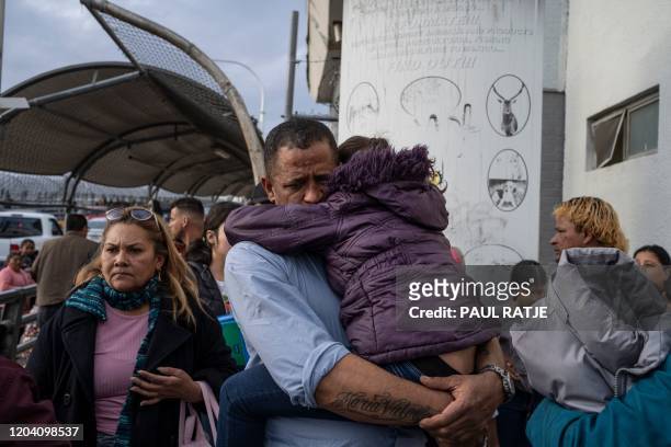 Man from Venezuela seeking asylum in the United States holds his daughter at the entrance to the Paso del Norte International Bridge after the news...