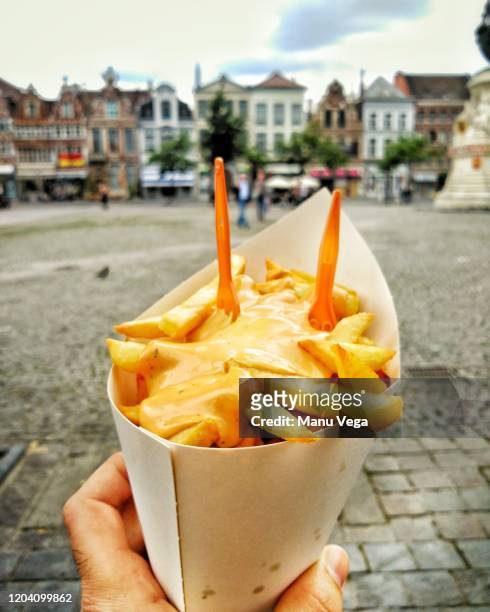hand holding delicious french fries on close up side view - stock photo - belgium stock-fotos und bilder