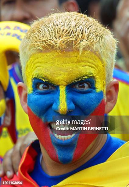 Soccer fan with his face painted with the colors of the Ecuadoran flag shouts 07 November, 2001 as he enters the Olympic Atahualpa Stadium in Quito...
