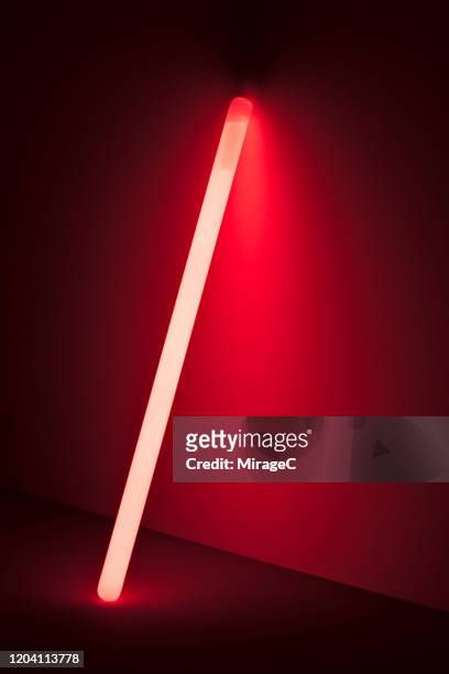 one red colored glow stick in the dark - fluorescente - fotografias e filmes do acervo