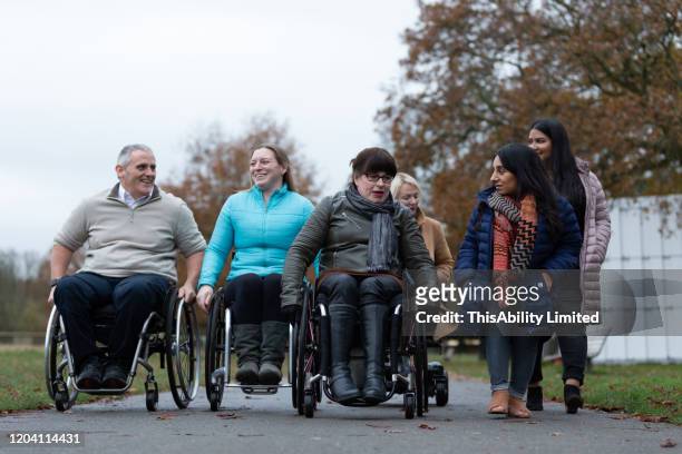 friends catching up in the park - disabilitycollection stock pictures, royalty-free photos & images