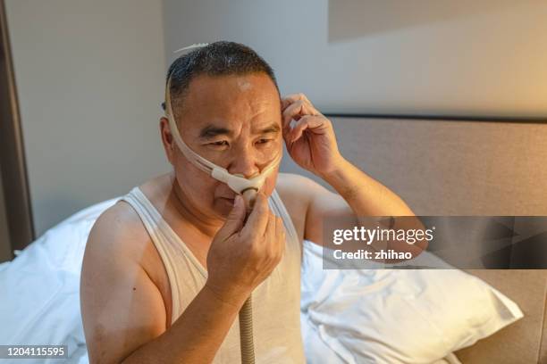 asian senior man using medical ventilator - ventilator stock pictures, royalty-free photos & images