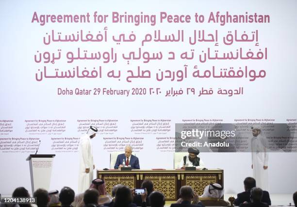Special Representative for Afghanistan Reconciliation Zalmay Khalilzad and Taliban co-founder Mullah Abdul Ghani Baradar sign a peace agreement...