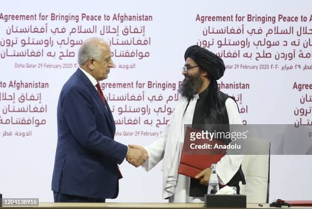 Special Representative for Afghanistan Reconciliation Zalmay Khalilzad and Taliban co-founder Mullah Abdul Ghani Baradar shake hands after signing...