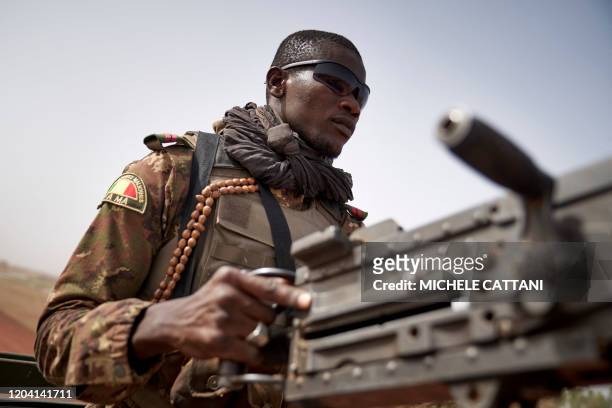 Soldier of the Malian army commands a machine gun during a patrol on the road between Mopti and Djenne, in central Mali, on February 28, 2020. A week...