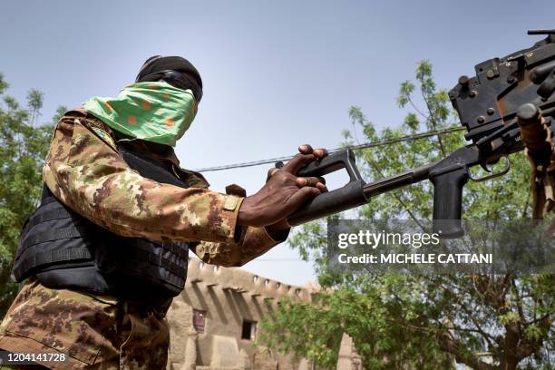 Soldier of the Malian army commands a machine gun during a patrol on the road between Mopti and Djenne, in central Mali, on February 28, 2020. - A...