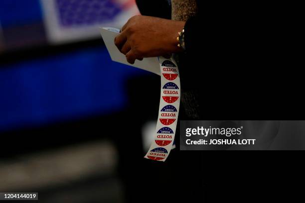 Poll station worker hold voting stickers at a polling station located at Mary Ford Elementary School during the primary election in North Charleston,...