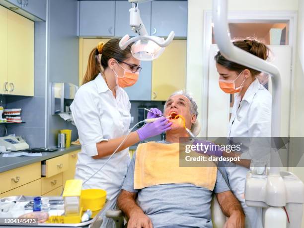 rijpe mens bij de tandarts - dental filling stockfoto's en -beelden