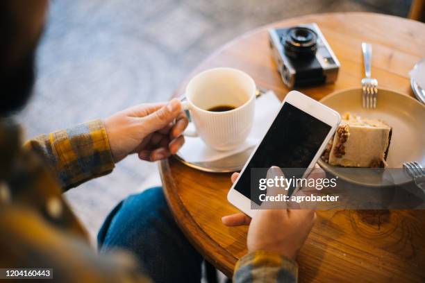 smartphone mit leerem bildschirm im café verwenden - smartphone mockup stock-fotos und bilder