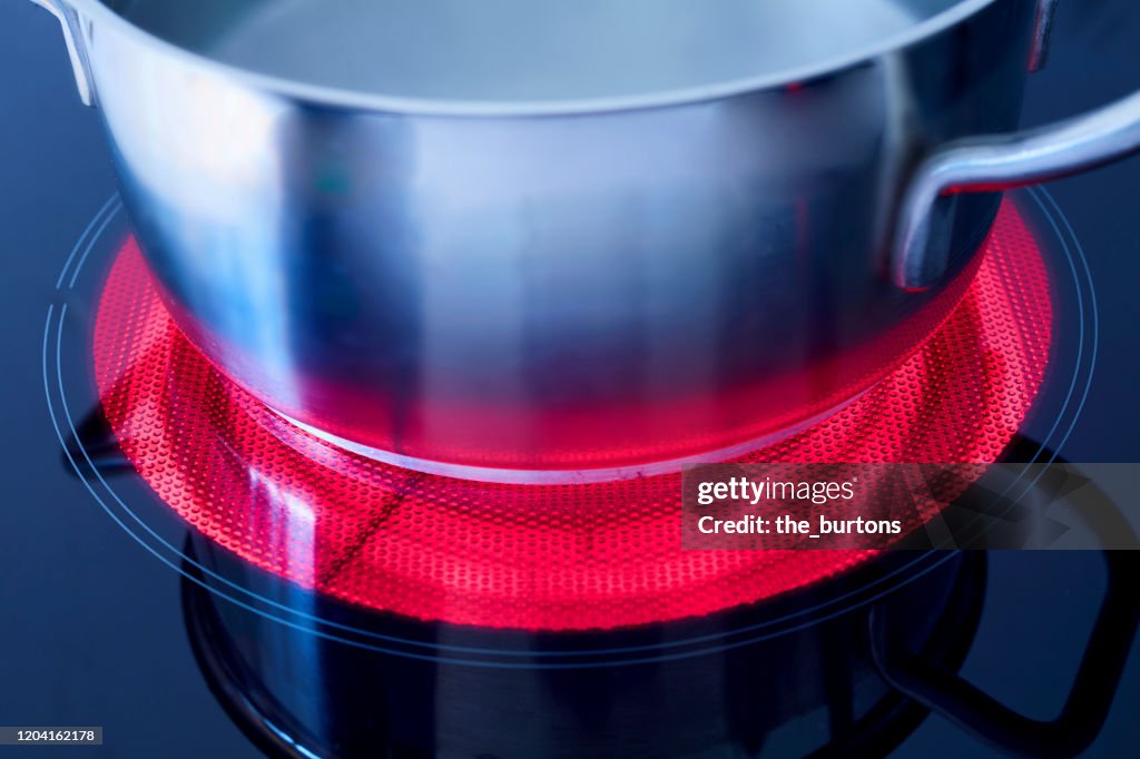 High angle view of a pot with boiling water on a heated ceramic stove top