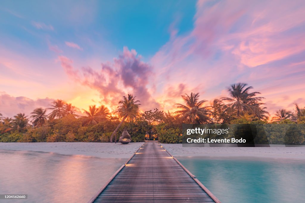 Beautiful sunset beach scene. Colorful sky and clouds view with calm sea and relaxing tropical mood