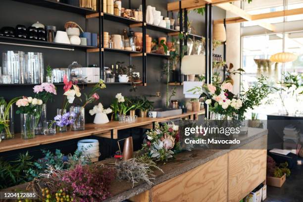 display of vases and floral arrangements in a flower shop - flower shop stock pictures, royalty-free photos & images