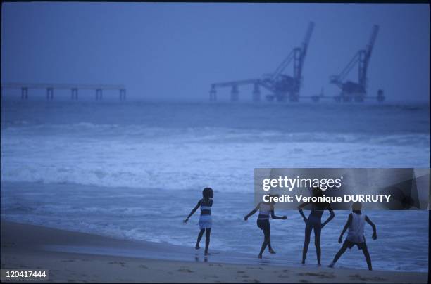 Children Playing On The Beach, Facing Oil Equipment In Pointe Noire, Congo.
