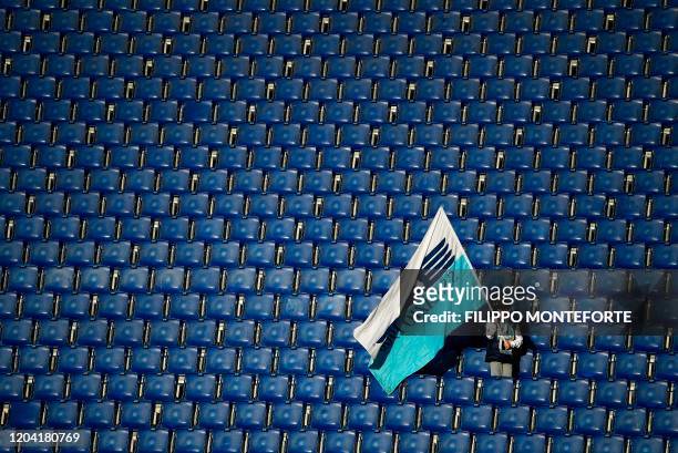 Lazio's supporter waves a flag of his team as he celebrates at the end of the Serie A football match between Lazio and Bologna at the Olympic Stadium...