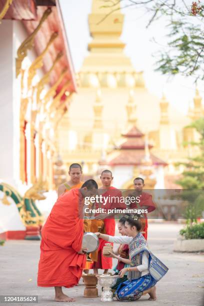 buddhist monks collecting alms in luang prabang laos - vientiane stock pictures, royalty-free photos & images