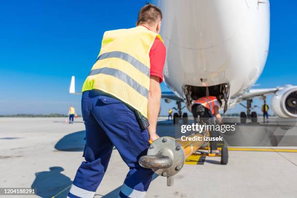 airport ground service at work - aircraft tug stock pictures, royalty-free photos & images