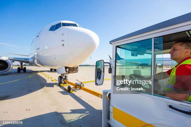 tripulación de tierra remolque avión a la pista - remolcar fotografías e imágenes de stock