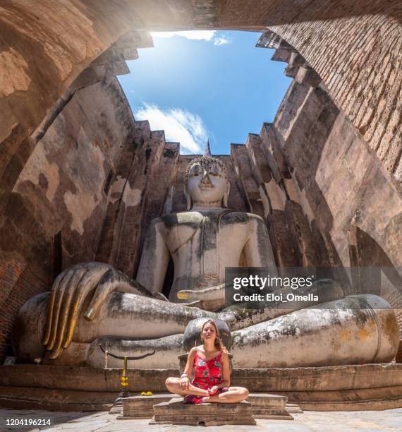 turista meditando frente a la estatua de phra ajana en wat si chum, sukhothai, tailandia - buda fotografías e imágenes de stock