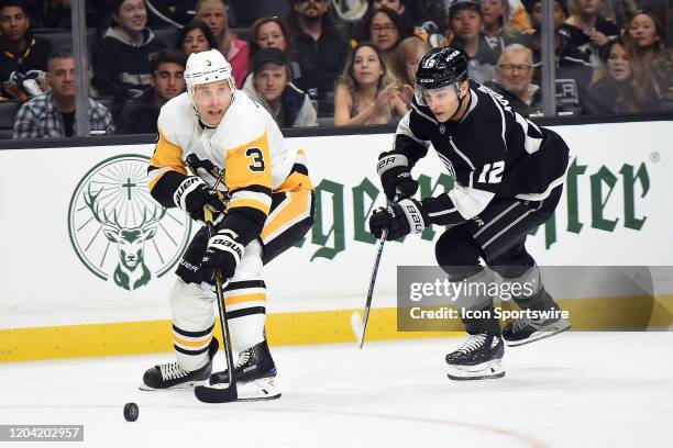 Pittsburgh Penguins defenseman Jack Johnson attempts to clear the puck past Los Angeles Kings left wing Trevor Moore during the game against the...