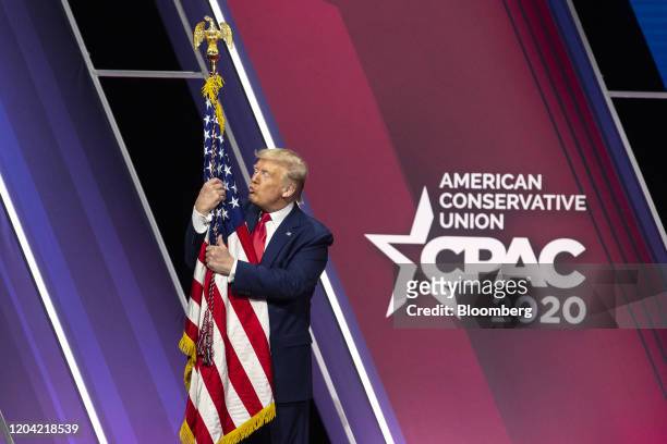 President Donald Trump hugs and kisses the American flag during the Conservative Political Action Conference in National Harbor, Maryland, U.S., on...