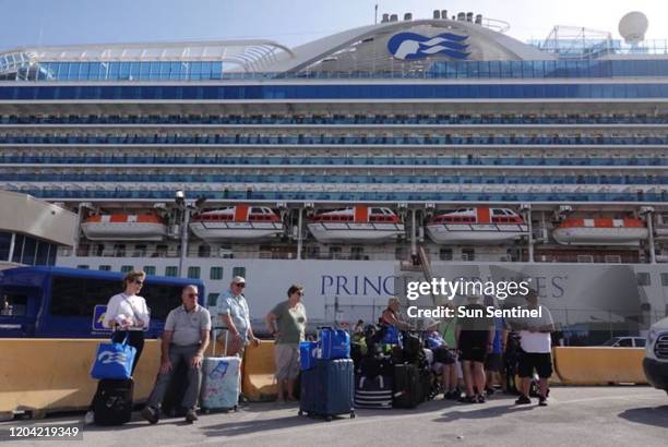 Passengers disembark from Princess Cruises' Caribbean Princess at Port Everglades on February 13 after the ship cut a 14-night cruise short because...