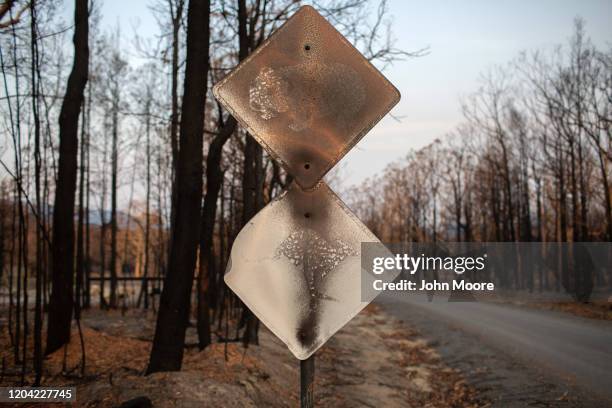 Bushfire damaged signs warning of koala and kangaroo crossing stand as a reminder of the intense blaze from weeks before on January 27, 2020 near the...