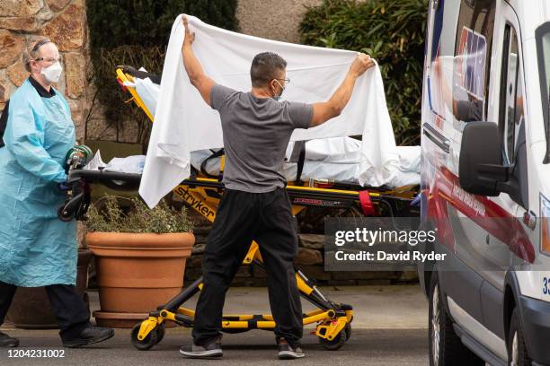 Healthcare workers transport a patient on a stretcher into an ambulance at Life Care Center of Kirkland on February 29, 2020 in Kirkland, Washington....