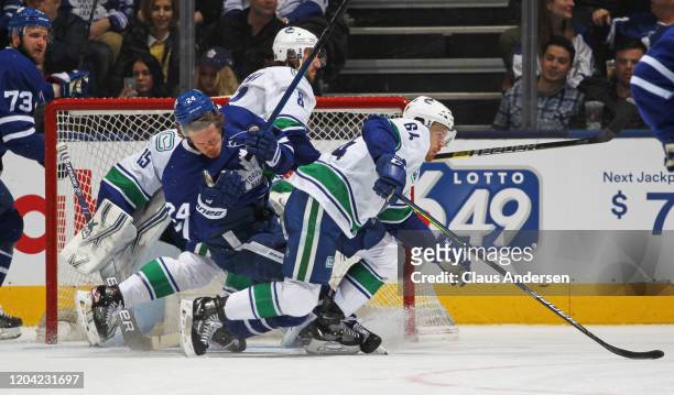 Christopher Tanev of the Vancouver Canucks draws a penalty for high sticking against Kasperi Kapanen of the Toronto Maple Leafs during an NHL game at...