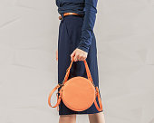 Stylish fashionable woman with orange round bag