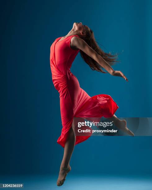 dancer in red dress on blue background - performer stock pictures, royalty-free photos & images