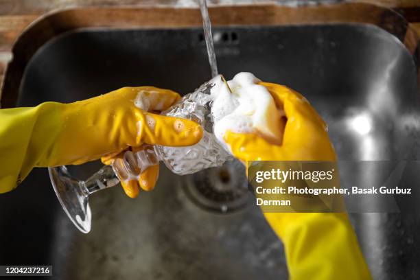 washing a wine glass with dish soap and soft sponge - brillos stockfoto's en -beelden