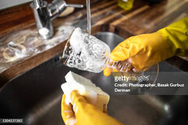 washing a wine glass with dish soap and soft sponge - brillos stockfoto's en -beelden