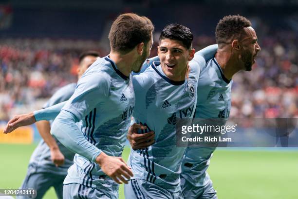 Alan Pulido of Sporting Kansas City celebrates with teammates Ilie Sanchez and Khiry Shelton after scoring a goal on the Vancouver Whitecaps during...