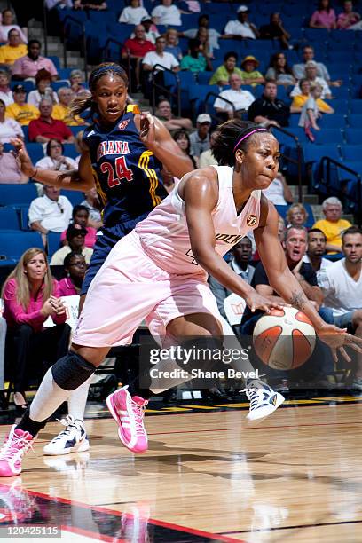 Tamika Catchings of the Indiana Fever watches as Amber Holt of the Tulsa Shock drives to the hoop during the WNBA game on August 5, 2011 at the BOK...