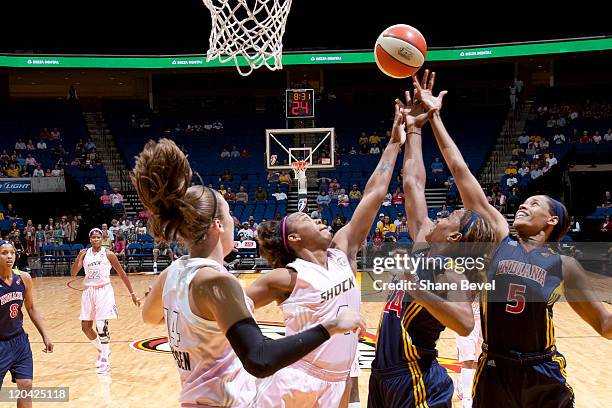 Tanglea Smith and Tamika Catchings of the Indiana Fever battle with Amber Holt of the Tulsa Shock for a rebound during the WNBA game on August 5,...